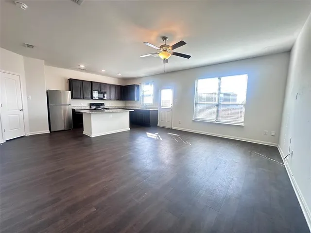 a view of kitchen with microwave a stove and wooden floor