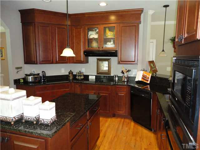 2 Rosemeade Place Durham, NC 27712 - Photo 8 of 20 a kitchen with granite countertop wooden cabinets stainless steel appliances and a sink