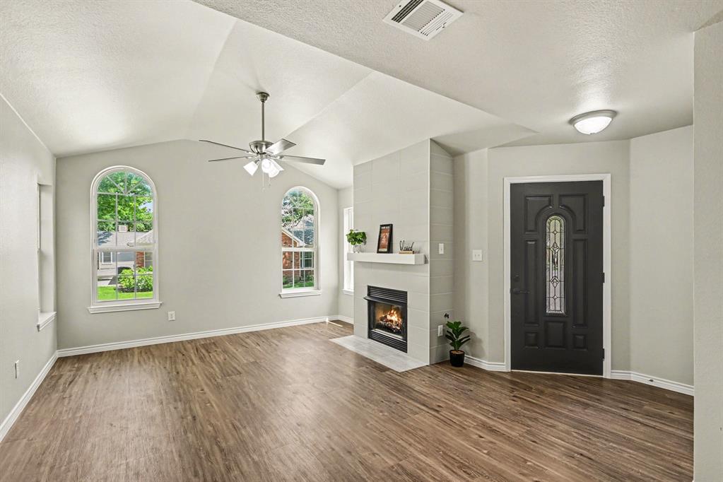 6113 Haley Lane Fort Worth, TX 76132 - Photo 8 of 38 Living room includes vaulted ceiling, gas fireplace, new luxury vinyl plank flooring and new ceiling fan.