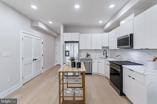 a kitchen with a refrigerator a stove a microwave and cabinets