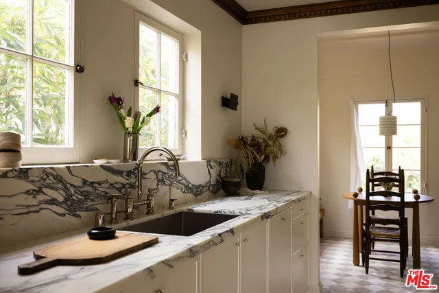 a bathroom with a granite countertop sink and a window