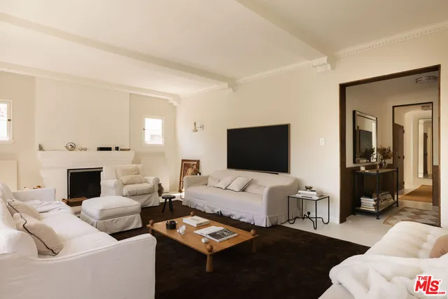 a view of a hallway and a livingroom with furniture