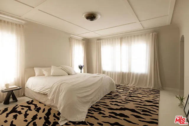 a bedroom with a bed and a potted plant