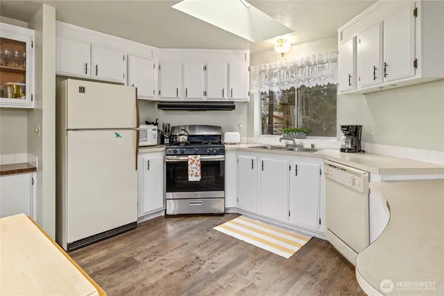 a kitchen with white cabinets and white appliances