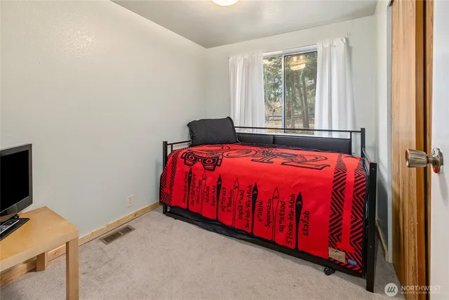 a bed sitting in a bedroom next to a window