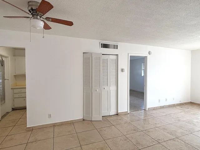 an empty room with closet and fan