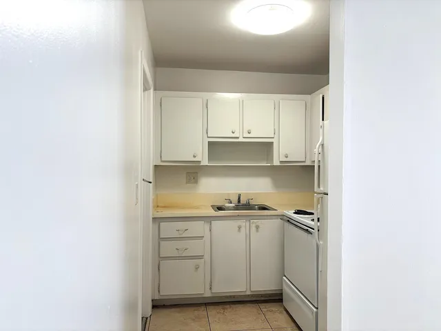 a view of a kitchen with white cabinets