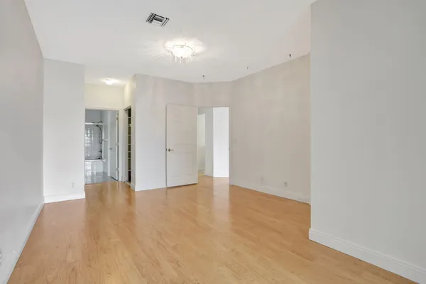 a view of an empty room with wooden floor