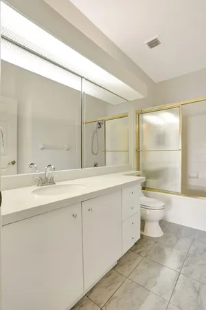 a bathroom with a granite countertop sink a toilet and a shower