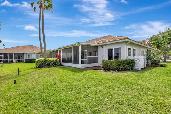 a view of a house with a big yard and potted plants