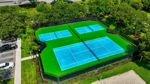 a green field with lots of trees in the background