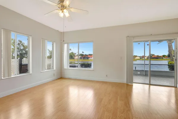 a view of an empty room with window and wooden floor
