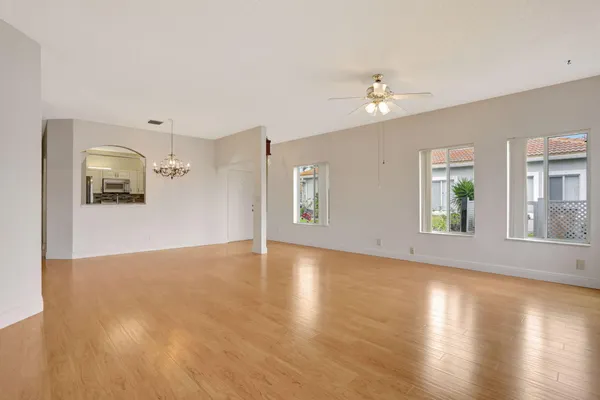 a view of an empty room with window and wooden floor