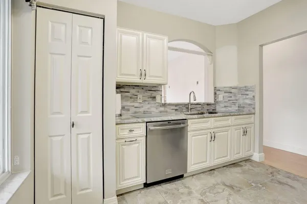 a kitchen with stainless steel appliances granite countertop white cabinets and sink