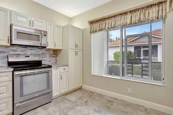 a kitchen with white cabinets and a stove top oven