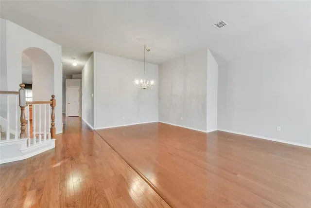 a view of a big room with wooden floor and windows