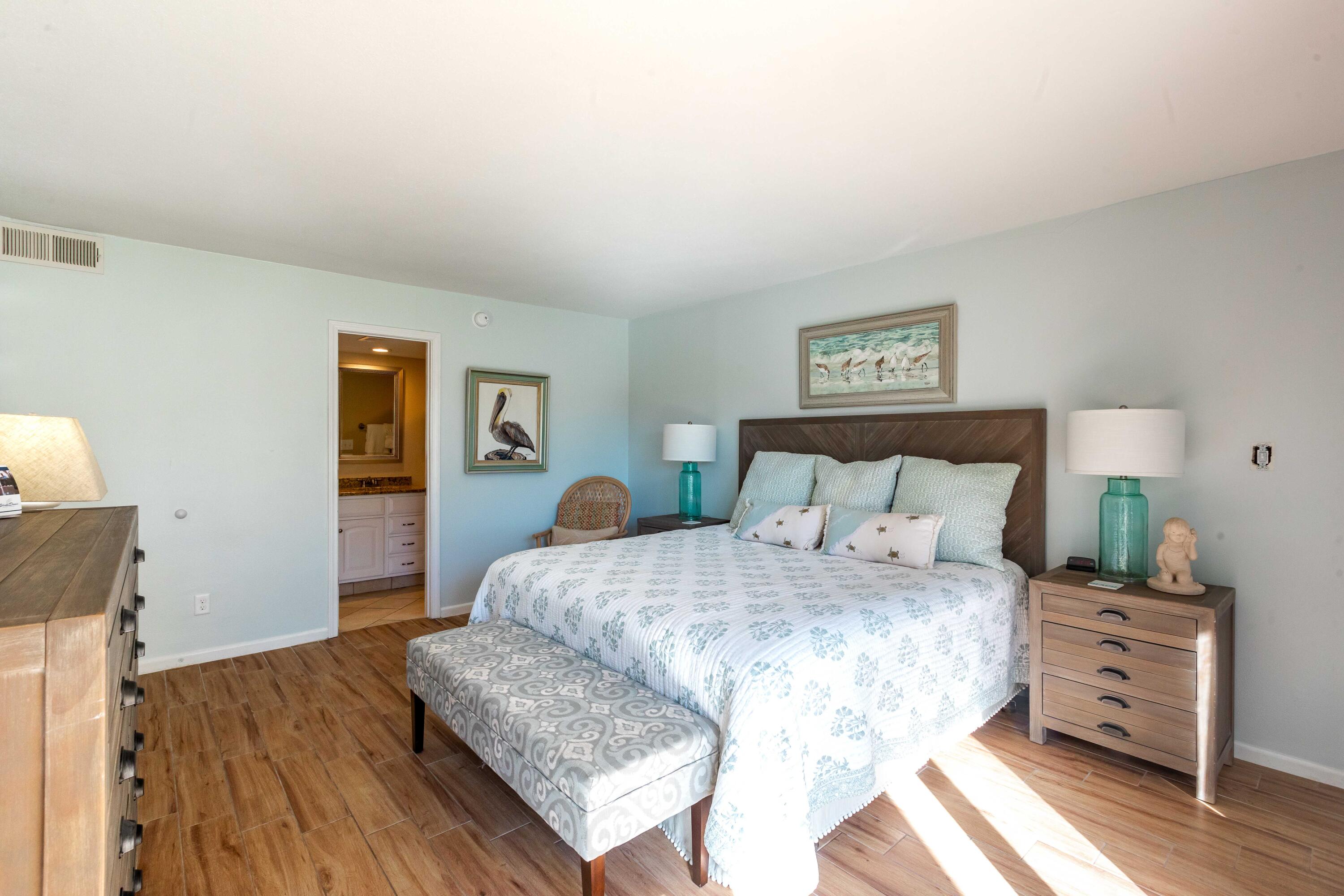 1030 East E Highway, Unit 25 Destin, FL 32541 - Photo 12 of 34 a bedroom with a bed and wooden floor