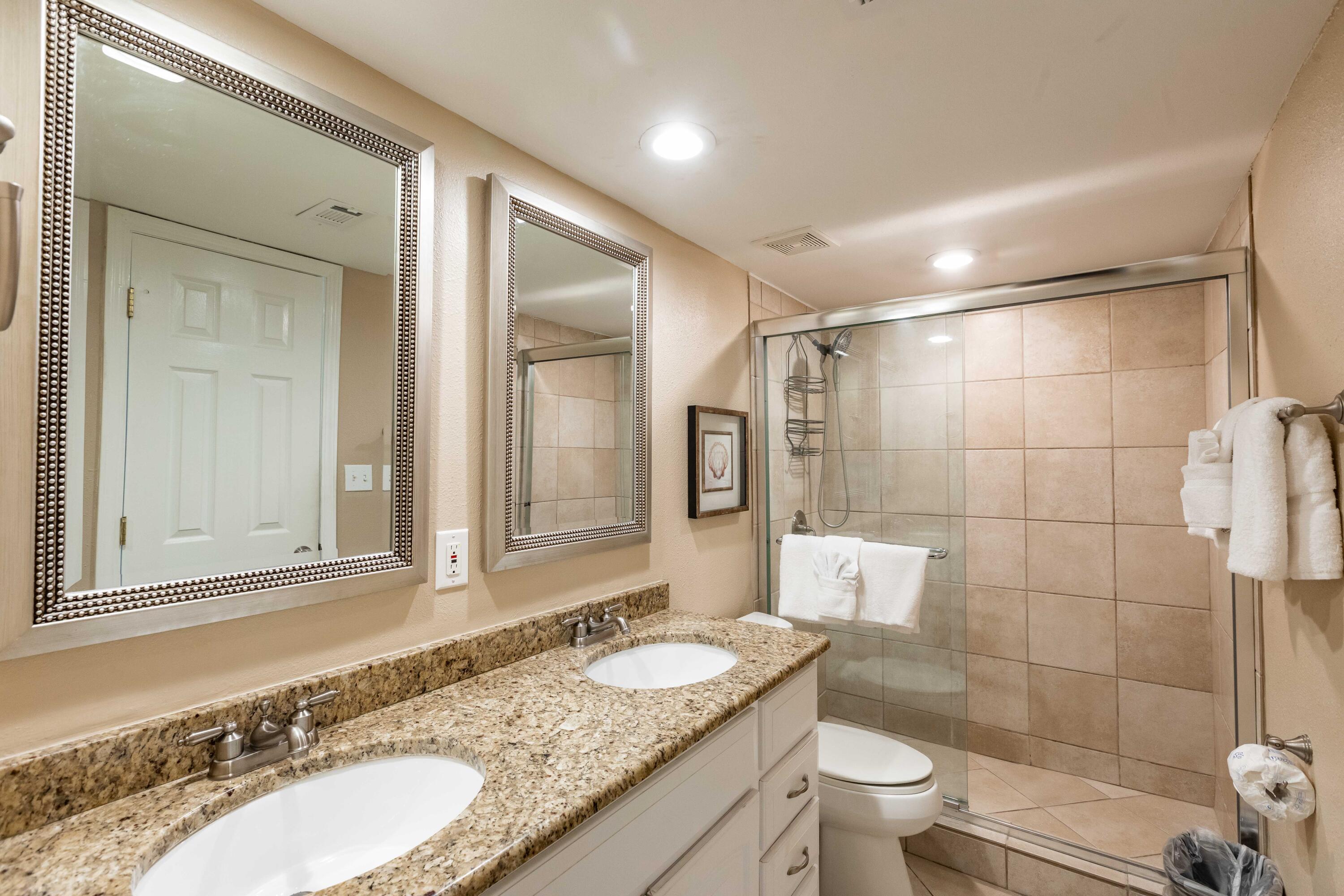 1030 East E Highway, Unit 25 Destin, FL 32541 - Photo 13 of 34 a bathroom with a granite countertop sink toilet a mirror and shower