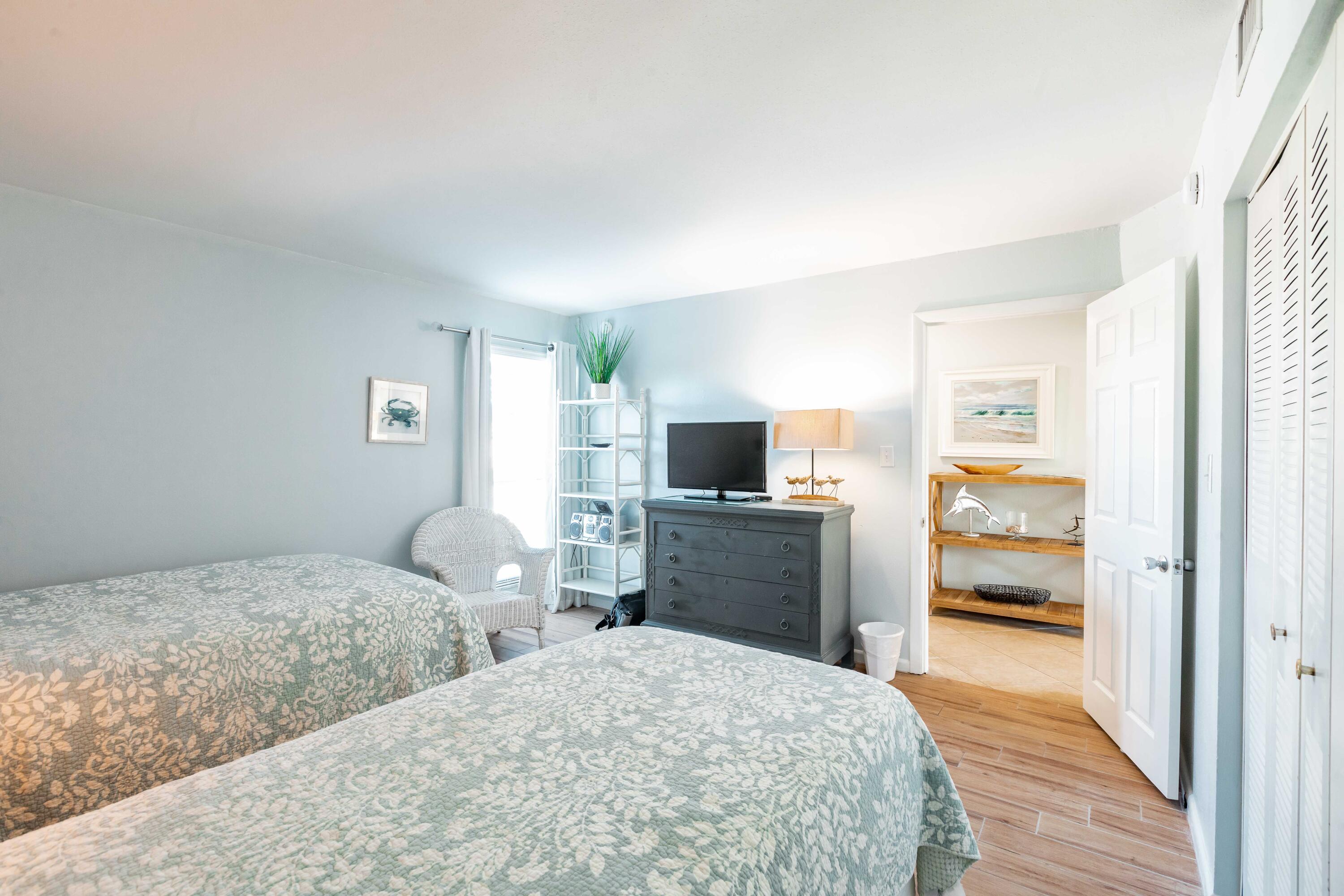 1030 East E Highway, Unit 25 Destin, FL 32541 - Photo 17 of 34 a bedroom with a bed and furniture