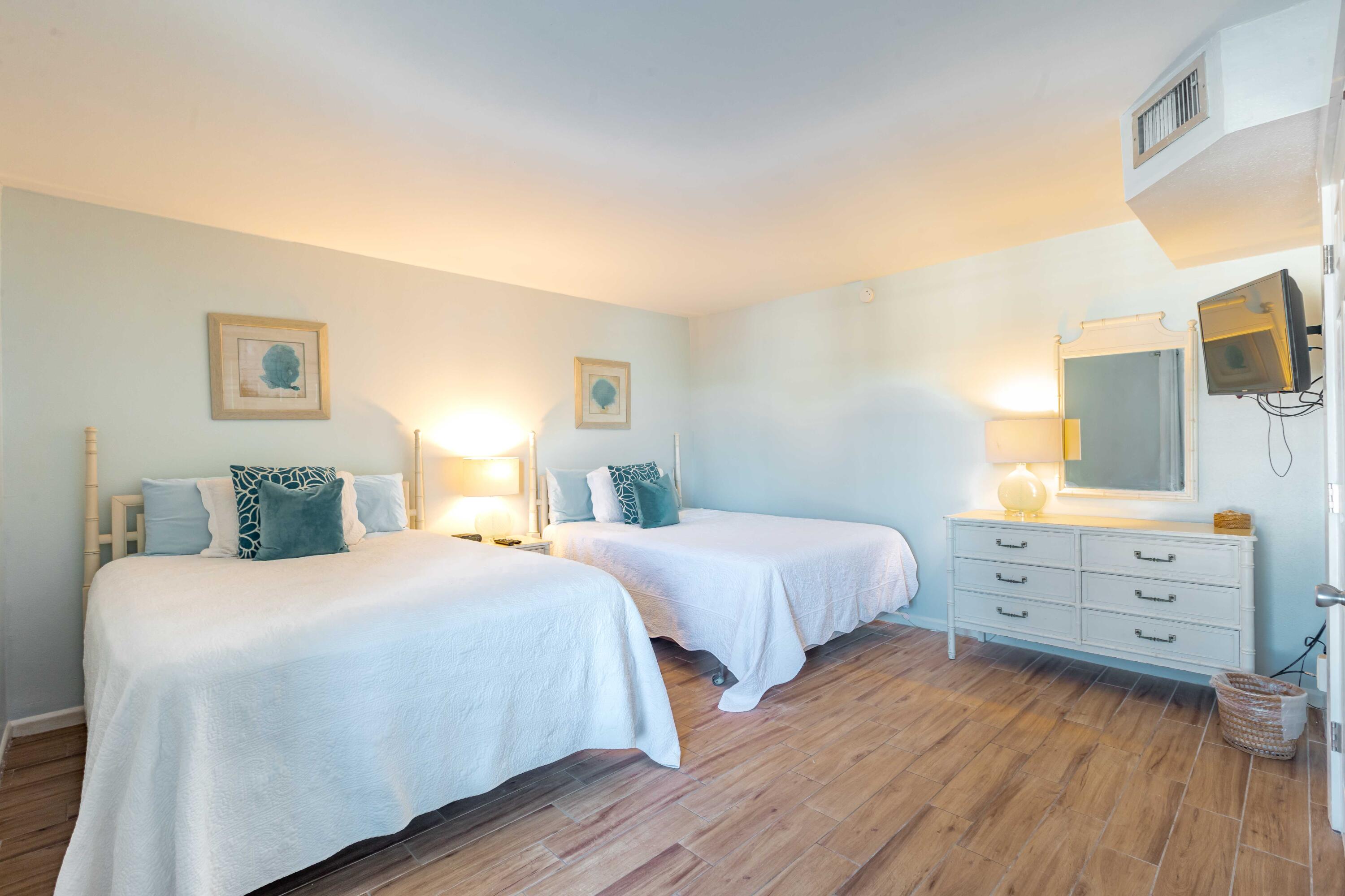 1030 East E Highway, Unit 25 Destin, FL 32541 - Photo 20 of 34 a bedroom with two beds and painting on the wall