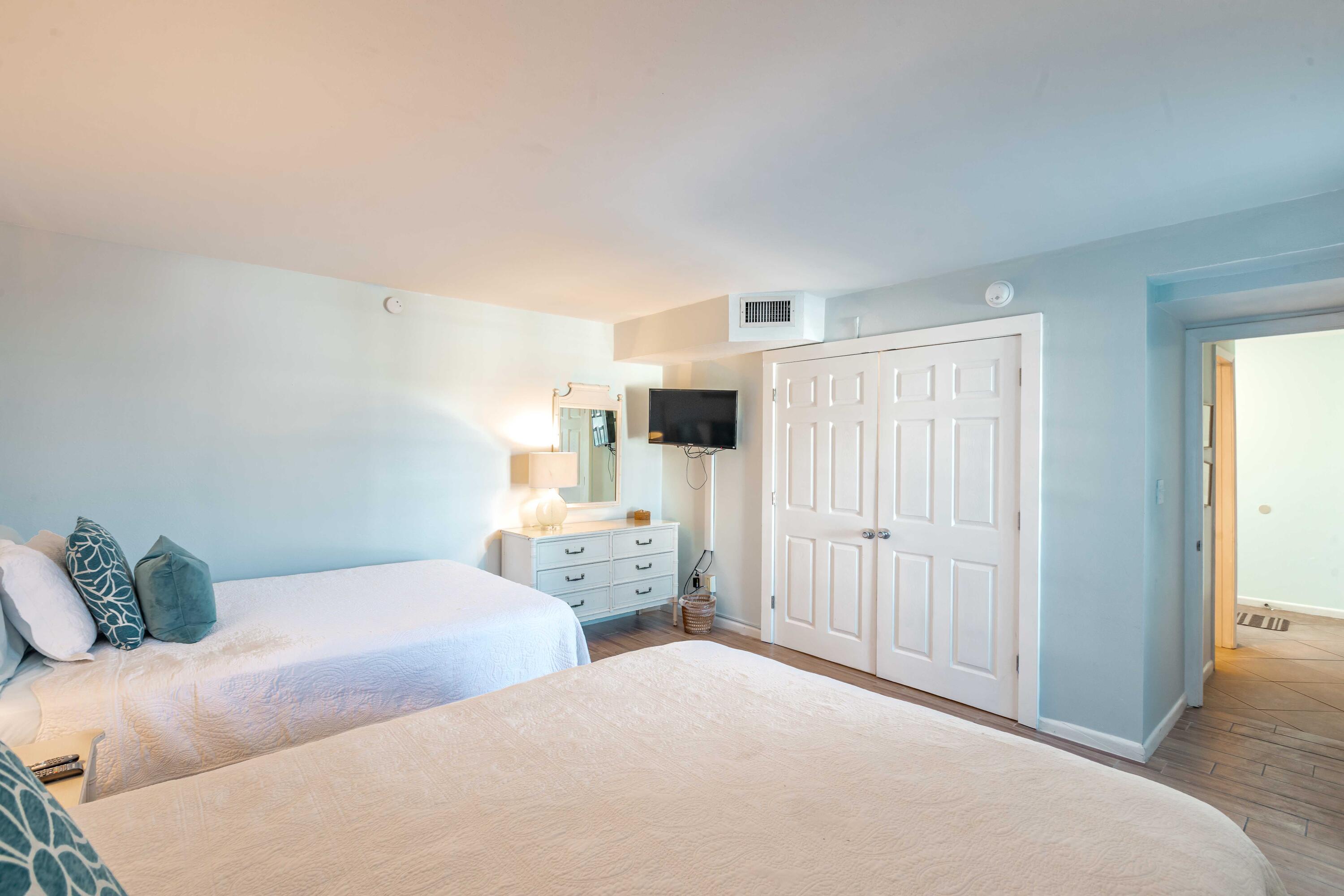 1030 East E Highway, Unit 25 Destin, FL 32541 - Photo 21 of 34 a bedroom with two beds and painted walls