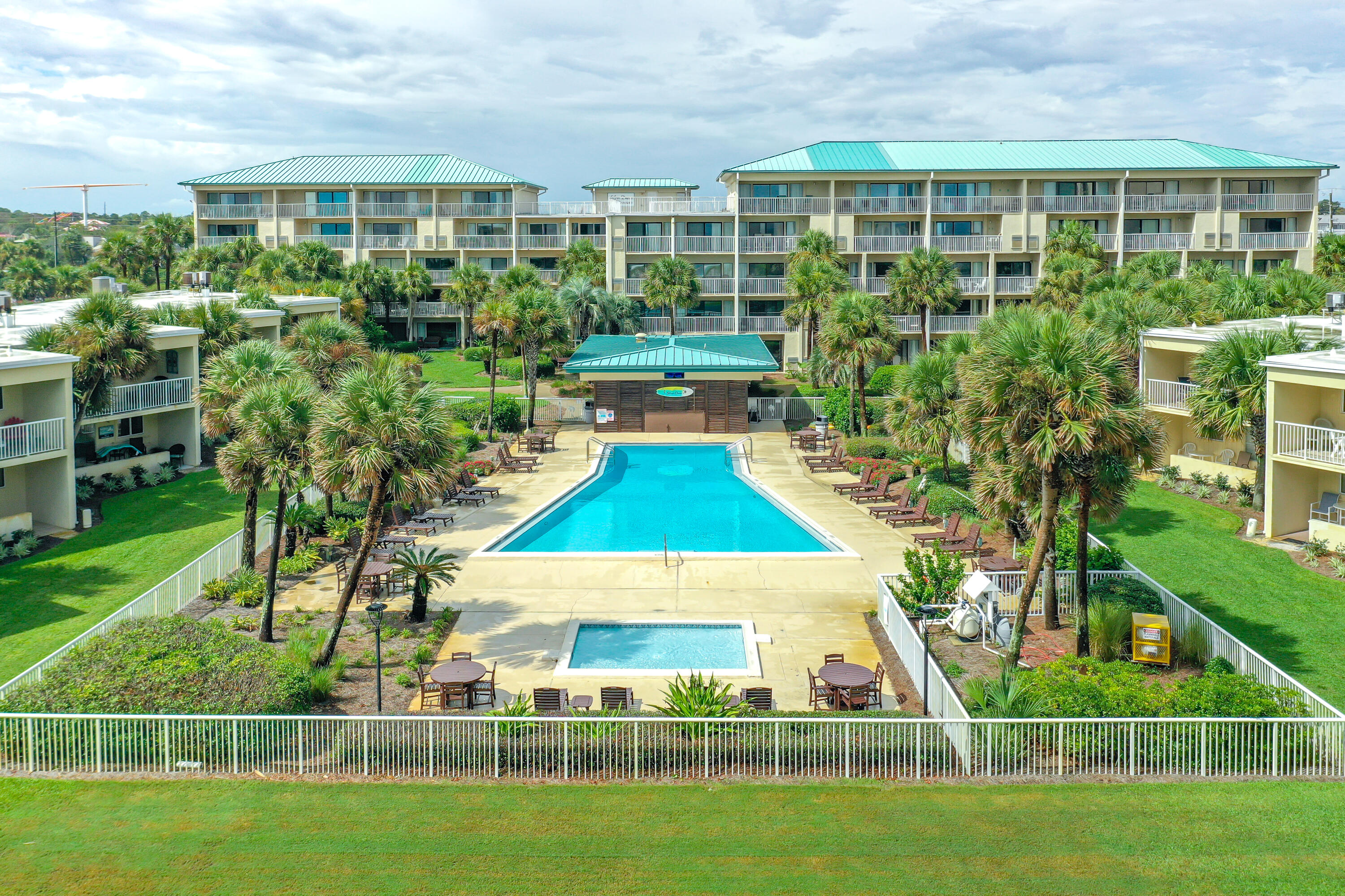 1030 East E Highway, Unit 25 Destin, FL 32541 - Photo 26 of 34 a view of a swimming pool with lawn chairs and plants