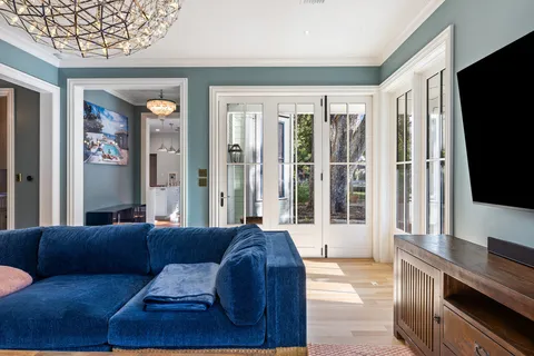 a living room with furniture a flat screen tv and a large window