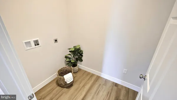 a view of an empty room with wooden floor and windows