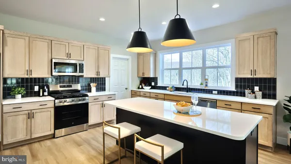 a kitchen with stainless steel appliances granite countertop a sink a stove and a microwave