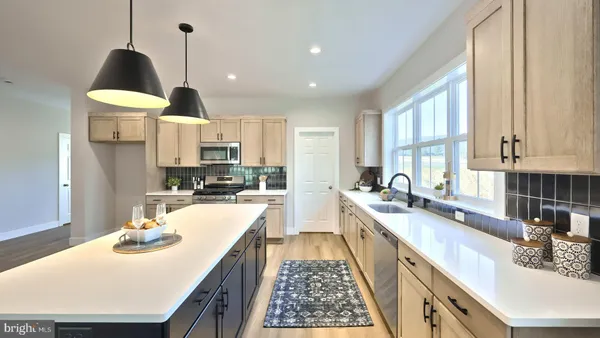 a kitchen with stainless steel appliances kitchen island granite countertop a sink a stove and a wooden cabinets
