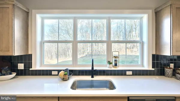 a kitchen with a sink a counter and a large window