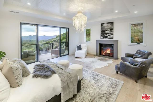 a spacious bedroom with a balcony a bed and a fireplace