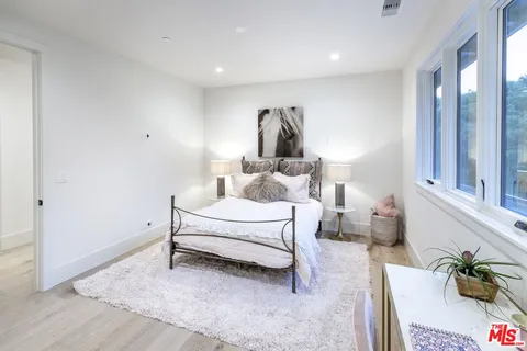 a bedroom with a bed lamp and a dresser