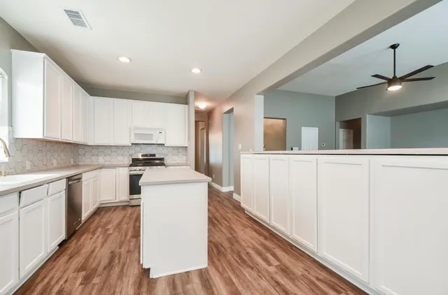 a kitchen with white cabinets and sink