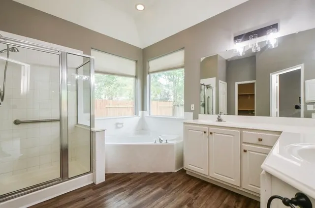 a large white bathroom with a large mirror a shower and vanity