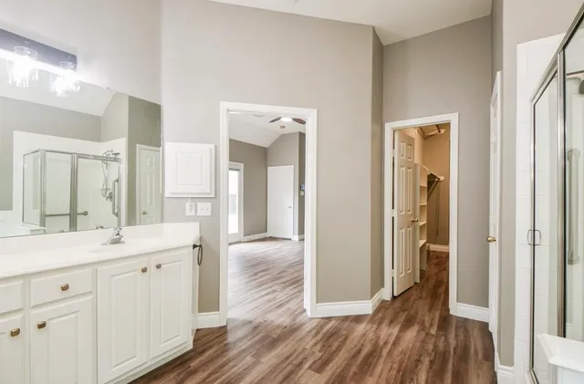 a en suite bathroom with a sink mirror and shower