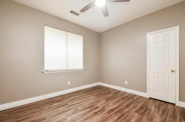 wooden floor in an empty room with a window