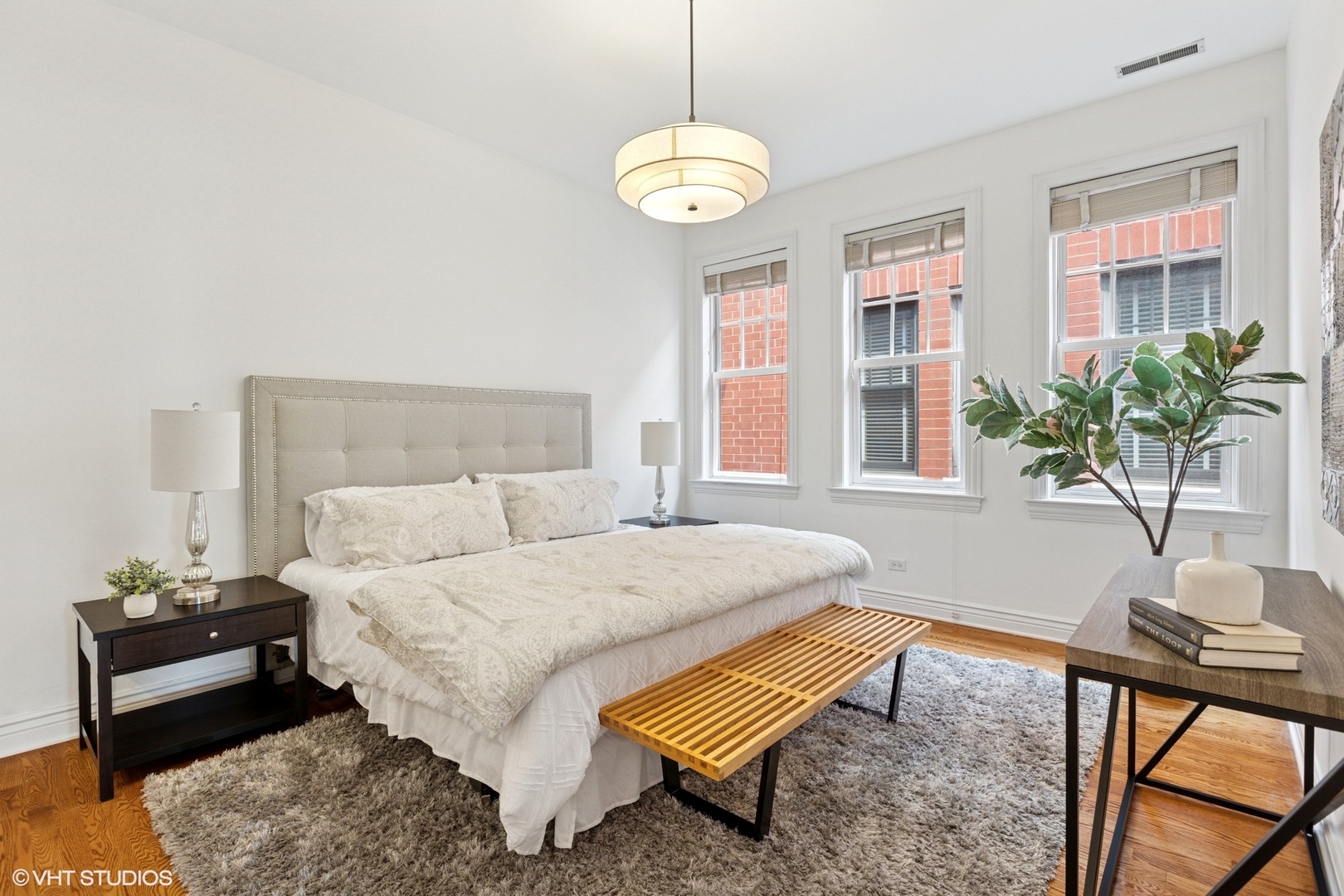 35 South Racine Avenue, Unit 6SE Chicago, IL 60607 - Photo 12 of 26 a bedroom with a bed and a chandelier