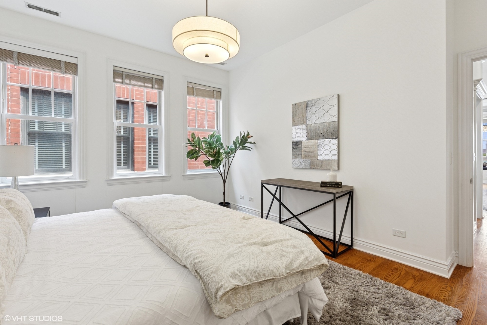 35 South Racine Avenue, Unit 6SE Chicago, IL 60607 - Photo 13 of 26 a bedroom with a bed and a chandelier