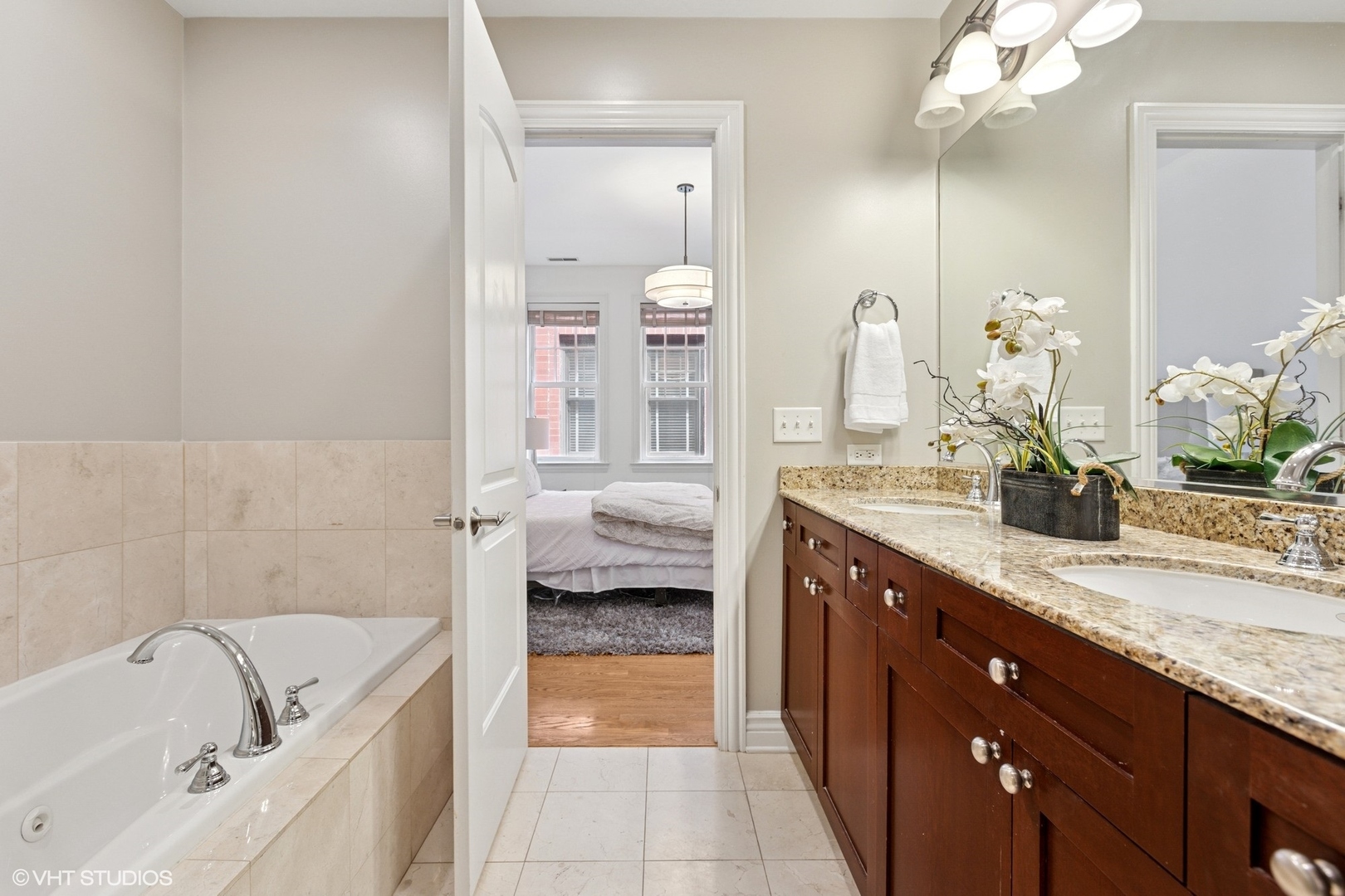 35 South Racine Avenue, Unit 6SE Chicago, IL 60607 - Photo 17 of 26 a spacious bathroom with a granite countertop sink and a mirror