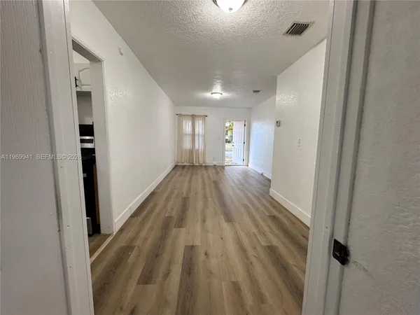 a view of a hallway with wooden floor
