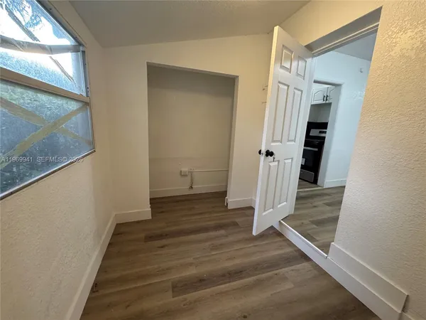 a view of a hallway with wooden floor and entryway