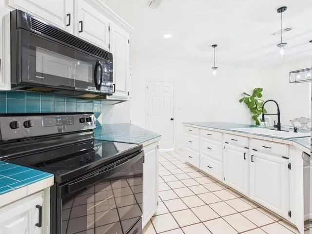 a kitchen with granite countertop white cabinets and appliances
