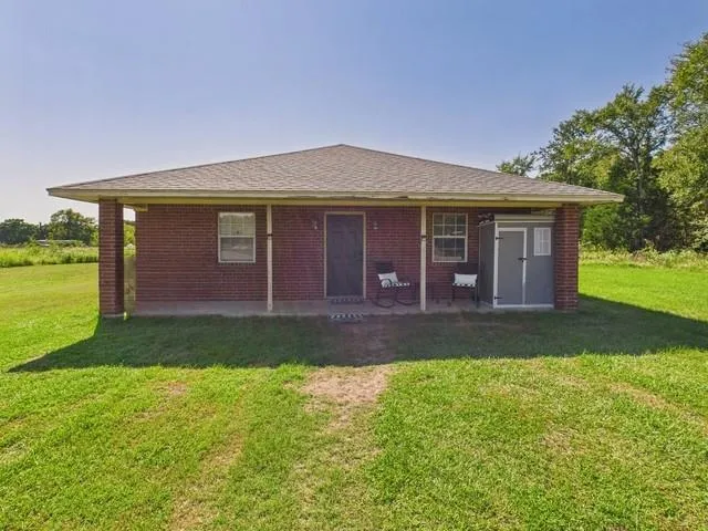 a view of a yard in front of a house with large trees