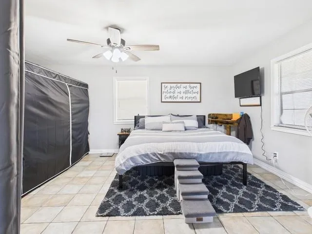 a bedroom with a large bed and a chandelier