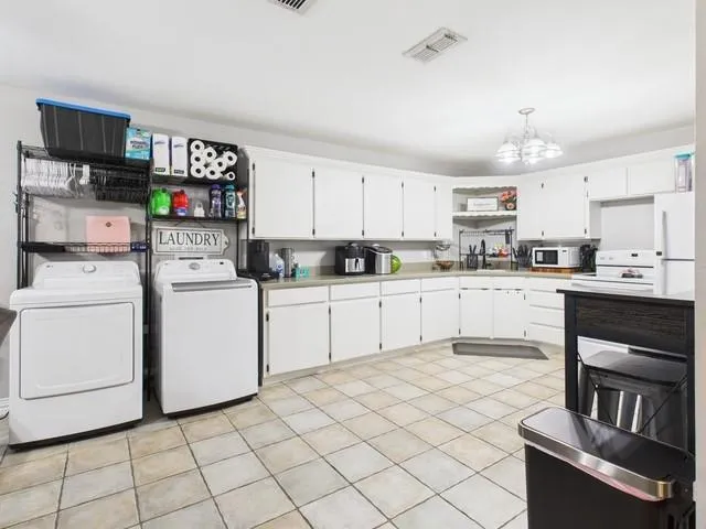 a kitchen with white cabinets and appliances