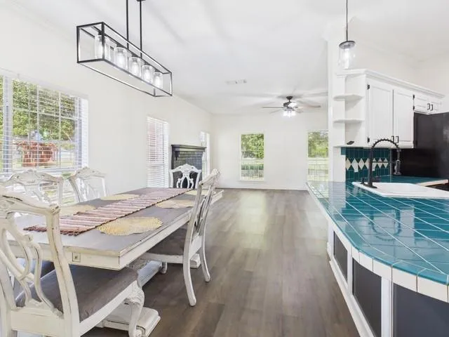 a view of a dining room and livingroom with furniture wooden floor a chandelier