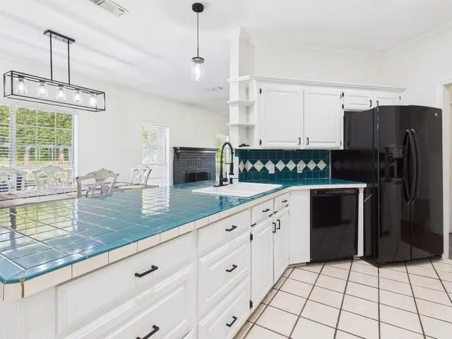a kitchen with granite countertop a refrigerator a stove a sink a counter space and cabinets