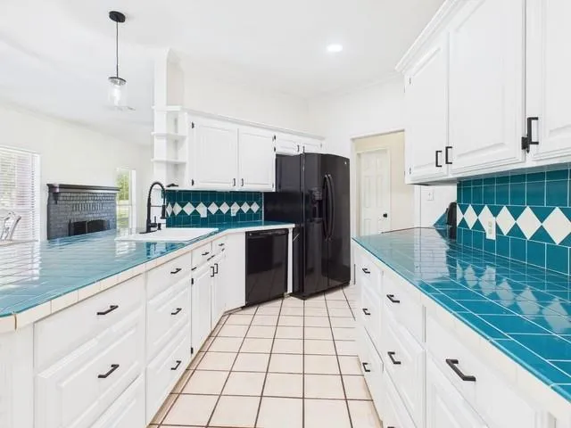 a kitchen with granite countertop a stove a sink and a refrigerator