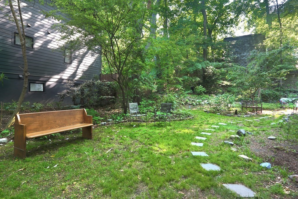 53 Brington Road Brookline, MA 02445 - Photo 11 of 12 a wooden bench sitting in the middle of a forest